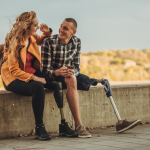 two young people sitting on a ledge talking to each other