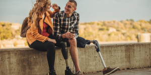 two young people sitting on a ledge talking to each other