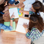 bird's eye view of students working; cell phones on the table