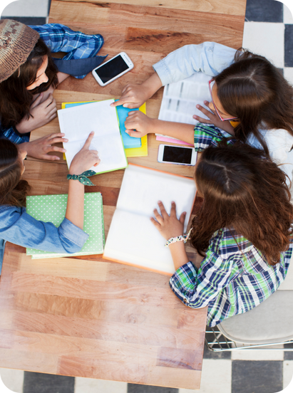 a group of people sitting around a table working in notepads