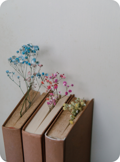 three books with flowers sitting on top of each other